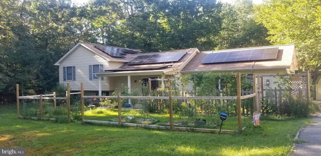 view of front of house featuring a front yard and solar panels