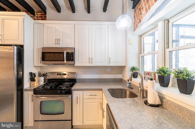 kitchen featuring white cabinets, stainless steel appliances, sink, decorative light fixtures, and beamed ceiling