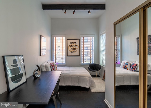 bedroom with beamed ceiling, carpet floors, and rail lighting