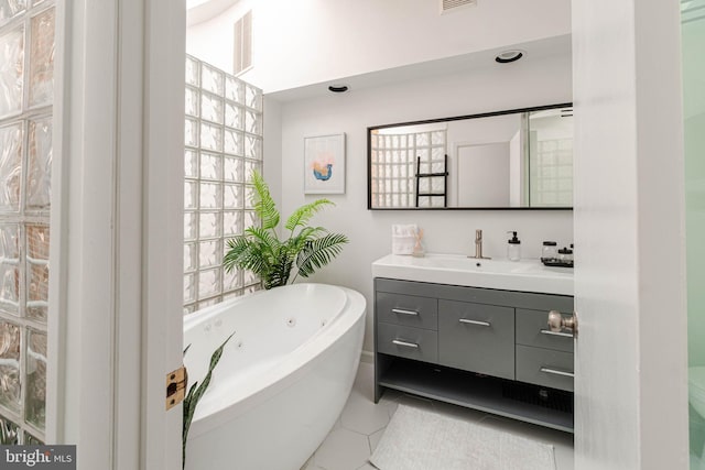 bathroom featuring tile patterned flooring, vanity, and a bathing tub