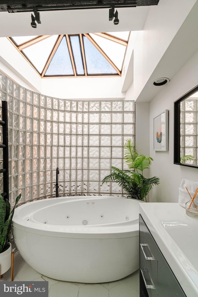 bathroom featuring tile patterned floors, a bathtub, sink, and a skylight