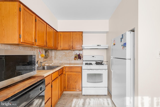 kitchen featuring sink, white appliances, and backsplash