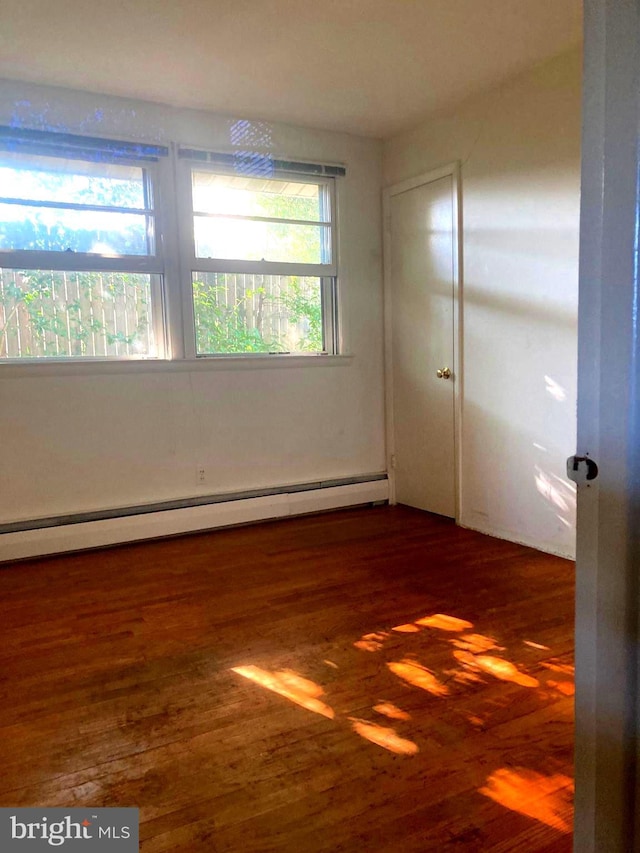 spare room featuring dark hardwood / wood-style flooring and baseboard heating