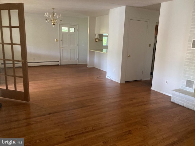 foyer with a chandelier, a baseboard heating unit, and dark wood-type flooring