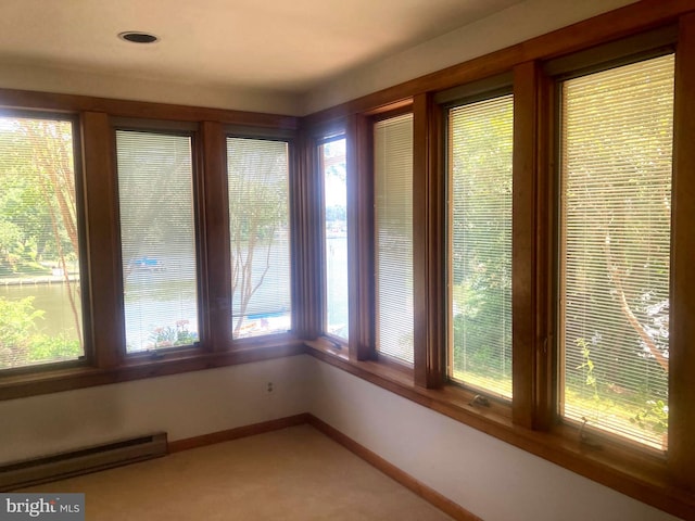 unfurnished sunroom featuring a healthy amount of sunlight and a baseboard radiator