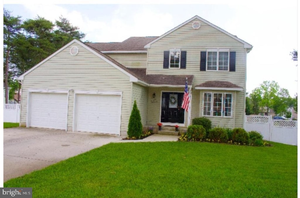 view of property featuring a front yard and a garage