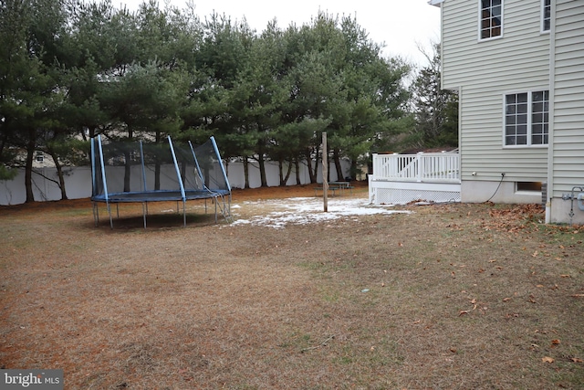 view of yard featuring a deck and a trampoline