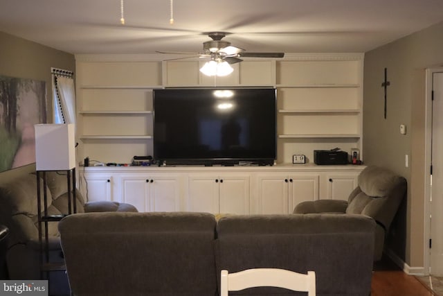 living room featuring ceiling fan, dark wood-type flooring, and built in features