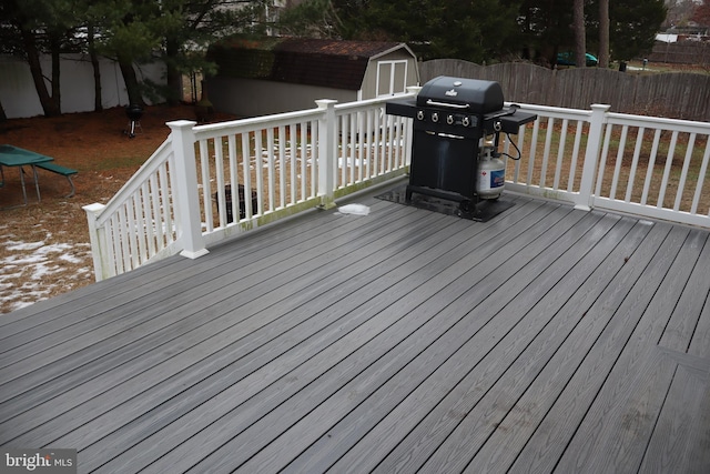 wooden deck with a shed and grilling area