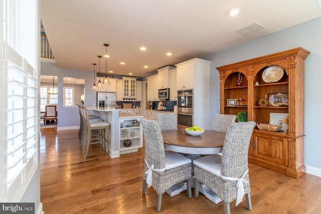 dining area featuring sink and light hardwood / wood-style flooring