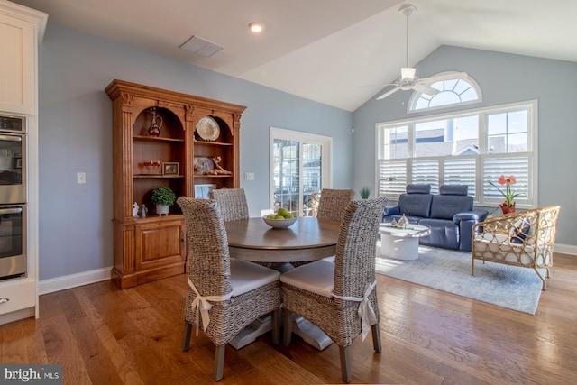 dining room with hardwood / wood-style flooring, ceiling fan, and lofted ceiling