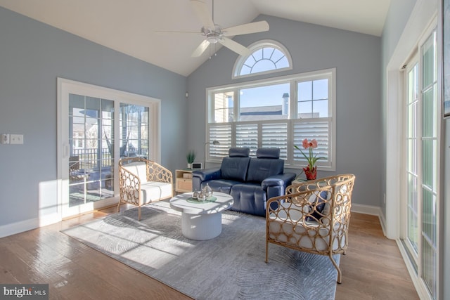 living room featuring light hardwood / wood-style floors, vaulted ceiling, and ceiling fan