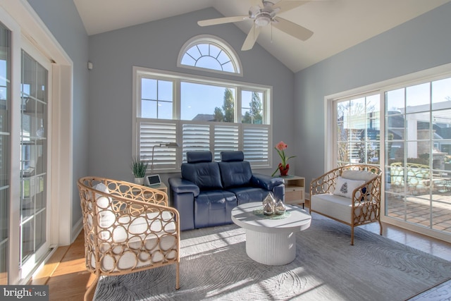 living room with ceiling fan, light hardwood / wood-style flooring, and vaulted ceiling