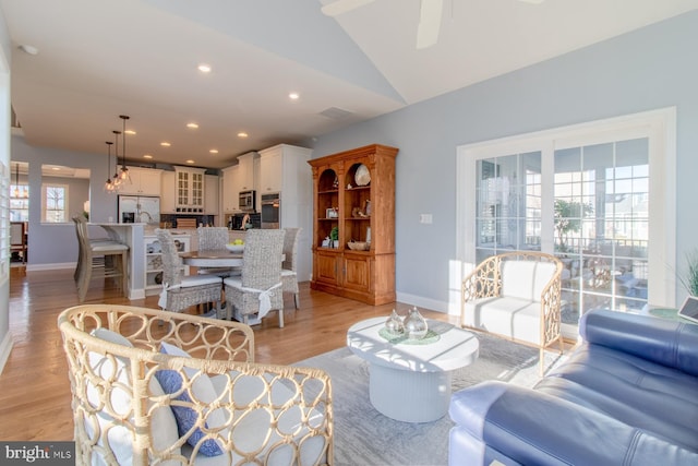 living room with light wood-type flooring and lofted ceiling