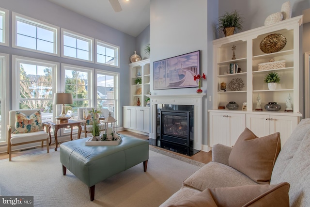 sitting room with a high ceiling, light hardwood / wood-style floors, and ceiling fan