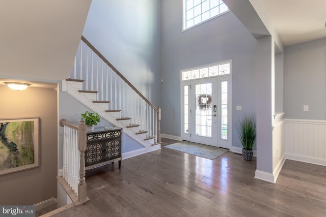 entrance foyer with a towering ceiling and dark wood-type flooring