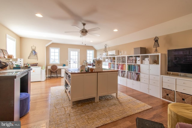 kitchen featuring ceiling fan, a center island, light hardwood / wood-style flooring, lofted ceiling, and white cabinets