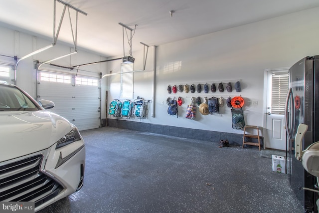 garage featuring stainless steel fridge and a garage door opener