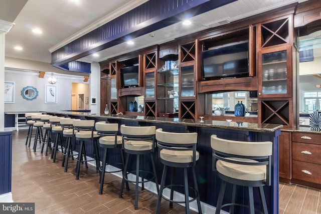 bar with crown molding and dark stone countertops