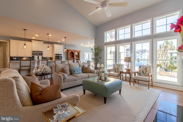 living room featuring ceiling fan and high vaulted ceiling