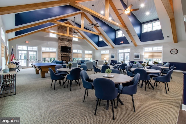 dining area with beam ceiling, french doors, high vaulted ceiling, a fireplace, and carpet