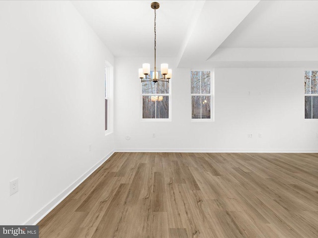 unfurnished dining area featuring hardwood / wood-style floors and an inviting chandelier