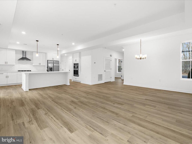 unfurnished living room with a chandelier and light hardwood / wood-style flooring