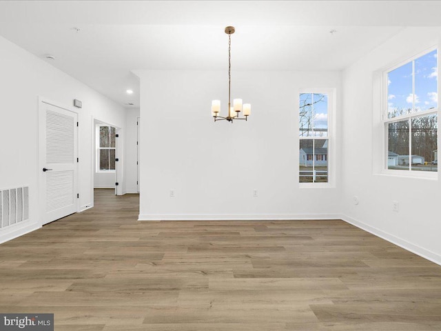 interior space featuring hardwood / wood-style flooring, plenty of natural light, and an inviting chandelier