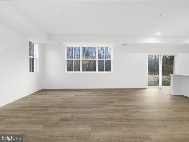 empty room with plenty of natural light and hardwood / wood-style flooring