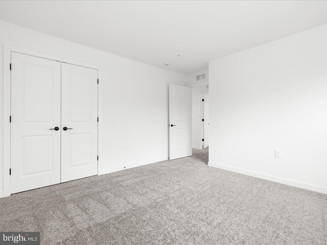 unfurnished bedroom with carpet floors and a closet