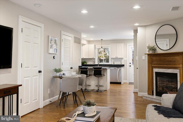 living room featuring a premium fireplace and light hardwood / wood-style flooring