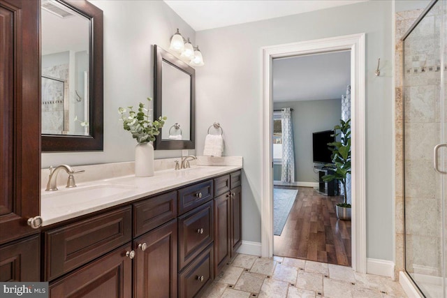 bathroom featuring vanity and a shower with shower door