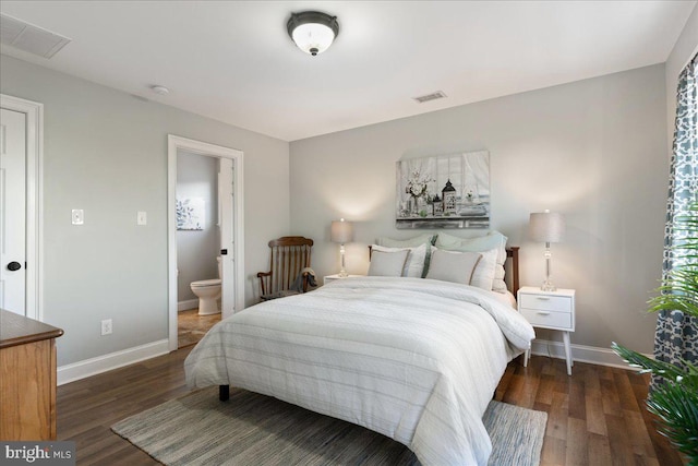 bedroom featuring dark hardwood / wood-style floors and ensuite bath