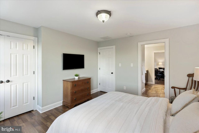 bedroom with dark hardwood / wood-style floors and a closet