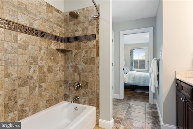 bathroom featuring tiled shower / bath combo and vanity