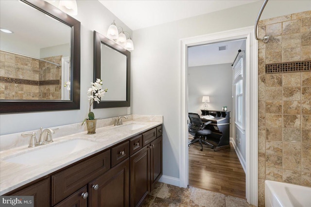 bathroom with vanity and tiled shower / bath