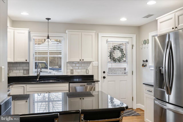 kitchen featuring white cabinets, backsplash, sink, and stainless steel appliances