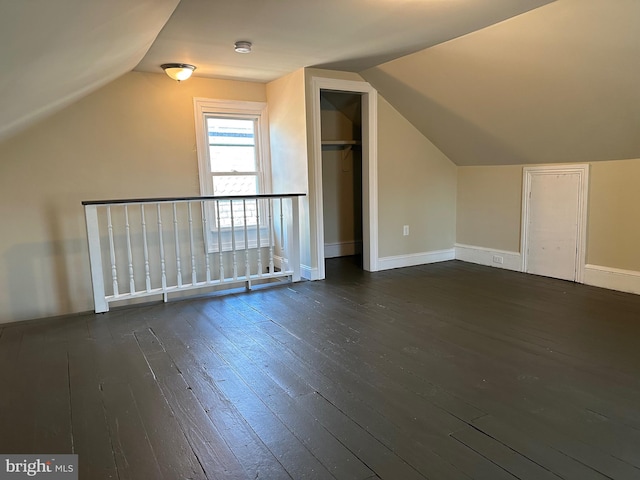 additional living space with dark hardwood / wood-style flooring, a baseboard radiator, and vaulted ceiling