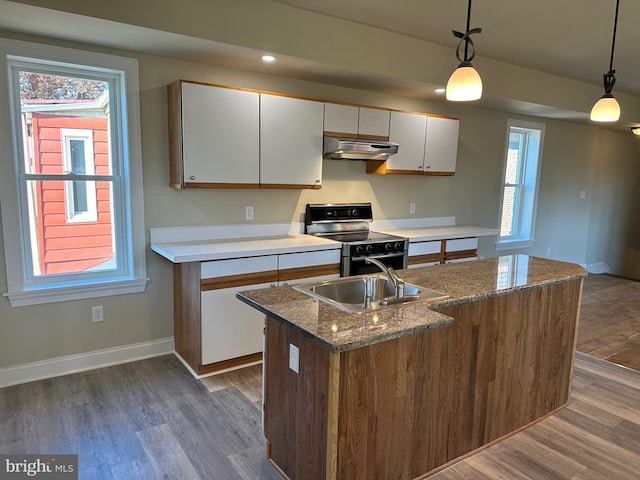 kitchen featuring stove, white cabinetry, hanging light fixtures, and a kitchen island with sink