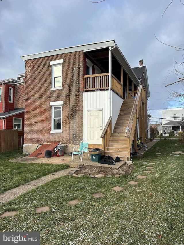 rear view of house featuring a yard