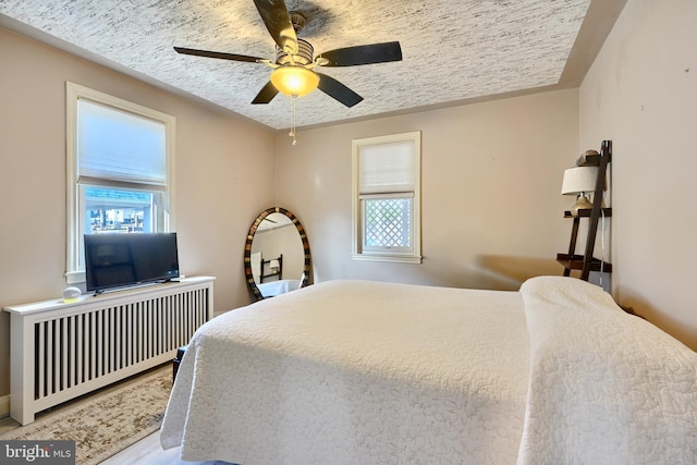 bedroom with radiator and ceiling fan