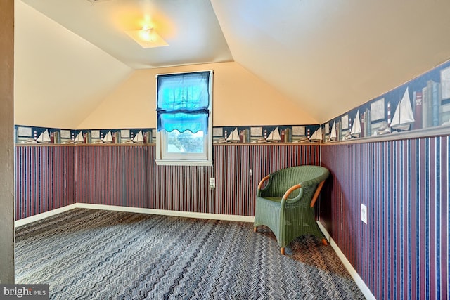 unfurnished room featuring carpet and lofted ceiling