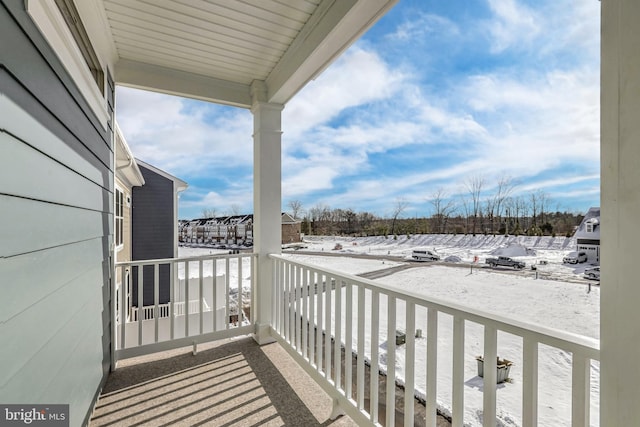 view of snow covered back of property