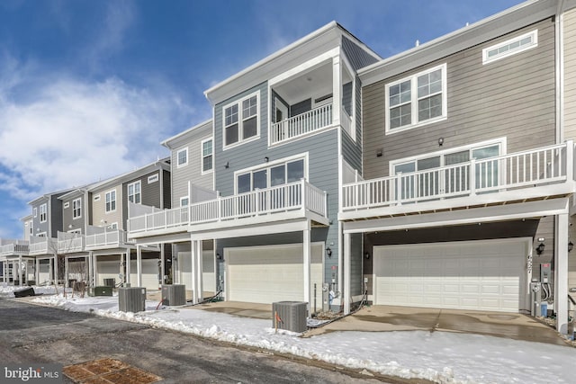 view of front of property with a balcony, a garage, and central AC unit