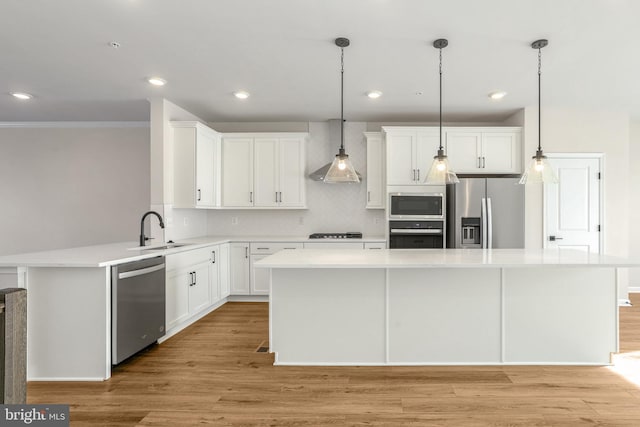 kitchen with white cabinets, appliances with stainless steel finishes, a center island, and sink