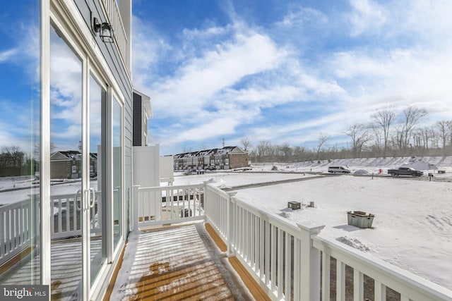 view of snow covered back of property