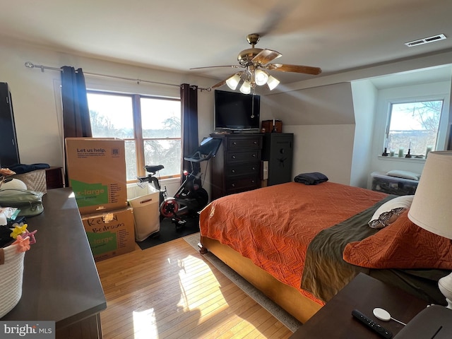 bedroom with ceiling fan, light wood-type flooring, and multiple windows