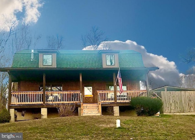 view of front facade with a wooden deck and a front lawn