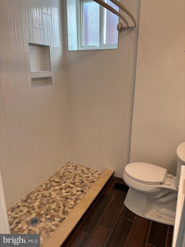 bathroom featuring toilet and tiled shower