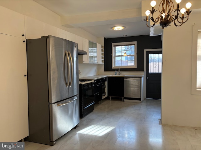 kitchen with a chandelier, sink, white cabinets, and stainless steel appliances